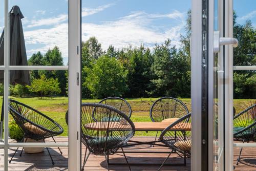 a patio with chairs and a table and an umbrella at Sodyba pas Brolius - Mažasis Namelis - Entire Barn House 85m2 in Priekulė