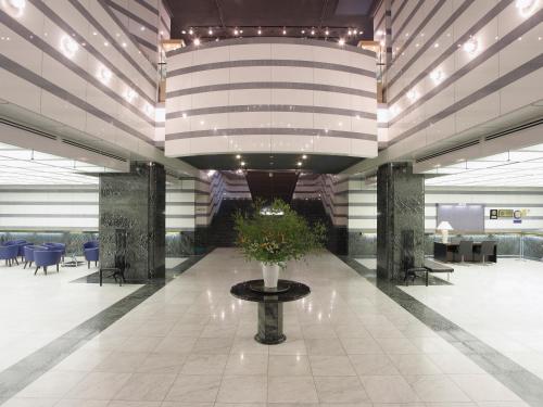 a lobby with a vase with flowers in it at Hotel Nikko Tsukuba in Tsukuba