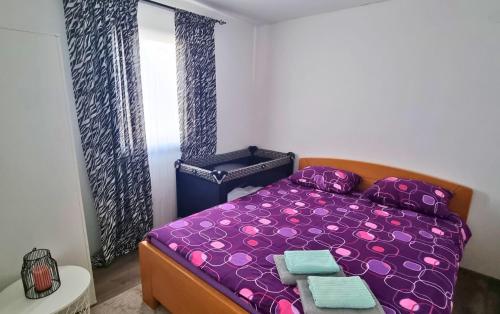 Un pequeño dormitorio con una cama morada y una ventana en EKO HOUSE en Kaludjerske Bare