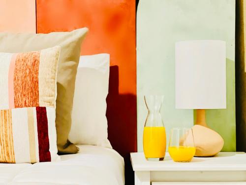 a bed with a vase and two glasses on a table at Canaryislandshost l Mar in Puerto del Carmen