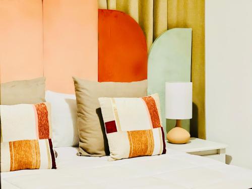 a white bed with pillows and a table with a lamp at Canaryislandshost l Mar in Puerto del Carmen
