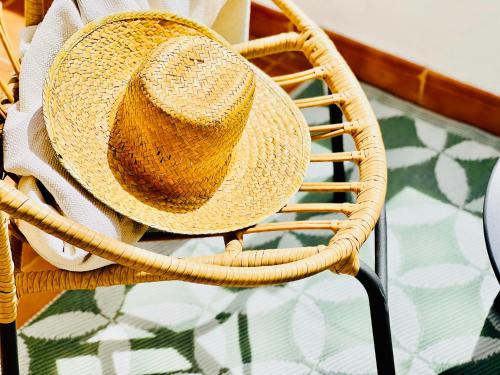 a straw hat sitting on a wicker chair at Canaryislandshost l Mar in Puerto del Carmen