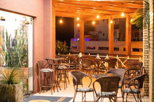 a patio with chairs and tables and a bar at Hotel Balneário in Marcelino Ramos