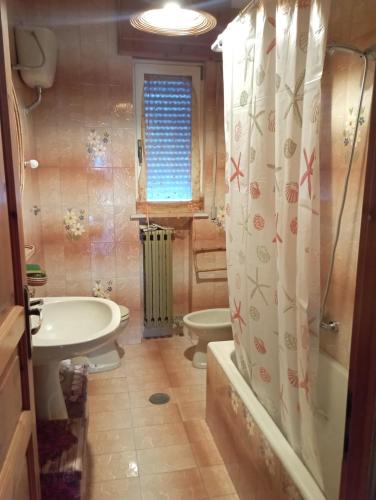 a bathroom with a tub and a toilet and a sink at Casa vacanze Il Carrubo in Leporano