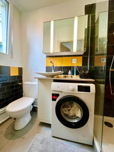 une machine à laver dans une salle de bain avec toilettes dans l'établissement Paris Ivry, à Ivry-sur-Seine
