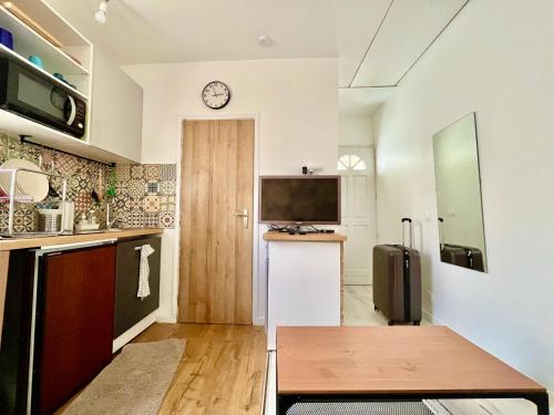 Il comprend une cuisine équipée d'un réfrigérateur et d'une horloge murale. dans l'établissement Paris Ivry, à Ivry-sur-Seine