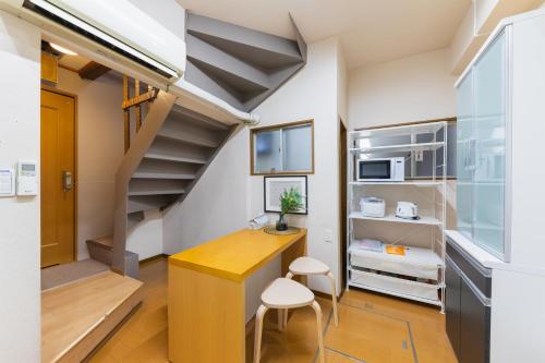 a small room with a desk and a staircase at Maru Taisho in Osaka