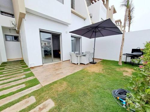 un patio con sombrilla, mesa y piano en Luxury Villa sea view en Agadir
