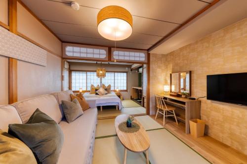 a living room with a couch and a television at Maru Taisho in Osaka