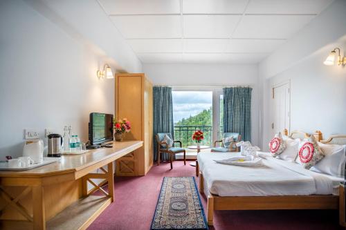 ein Hotelzimmer mit einem Bett und einem Schreibtisch in der Unterkunft Toshali Royal View ,S H I M L A in Kūfrī