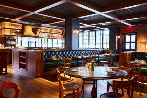 a restaurant with tables and chairs and a bar at The Junto Hotel in Columbus