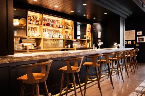 a bar with a row of bar stools at The Junto Hotel in Columbus