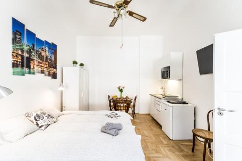 ブダペストにあるCorbie Downtown Apartmentの白いベッドルーム(ベッド2台付)、キッチンが備わります。