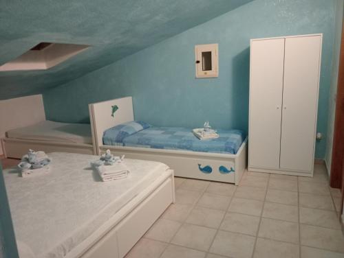 1 dormitorio con 2 camas y armario pequeño en casetta al mare, en Sapri