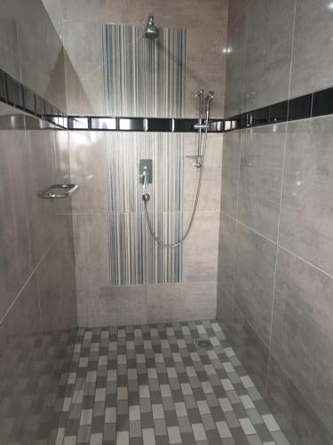 a shower with a glass door in a bathroom at Lotus Accommodation in Kingsburgh