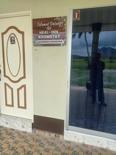 a person standing outside of a heal inn reception door at Heal Inn - Islamic Guest Chalet in Kangar