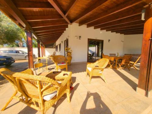 a patio with wicker chairs and a table and chairs at Scirocco Home in Marsala