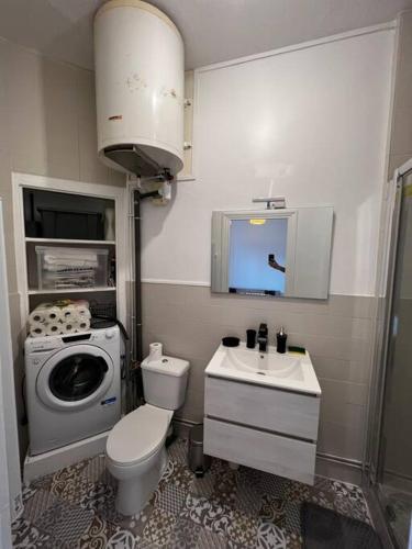 une salle de bain avec un lavabo et une machine à laver dans l'établissement Appartement T2 avec terrasse proche cathédrale, à Bourges