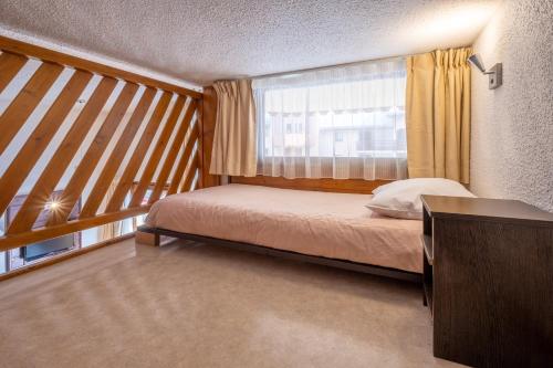 a small bedroom with a bed and a window at VVF Val-Cenis Haute-Maurienne in Lanslevillard