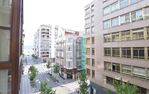 una vista da una finestra di una città con edifici alti di JUST-ROOM. Apartamento Javier a Santander