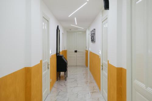 a hallway with white walls and a door and a chair at AFFITTACAMERE ELENA in Sanremo