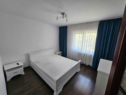 um quarto com uma cama branca e uma janela em Apartament Rebeca Central em Târgu Jiu
