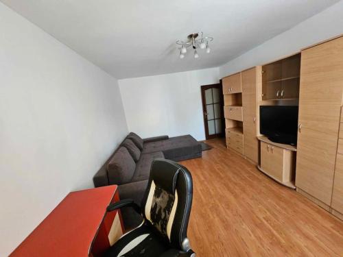 uma sala de estar com um sofá, uma mesa e uma televisão em Apartament Rebeca Central em Târgu Jiu