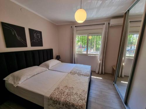 een slaapkamer met een groot bed en een raam bij Brian's Apartment in Tirana in Tirana