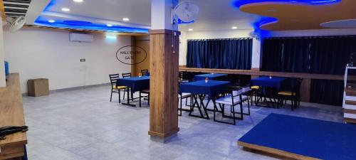 a dining room with blue tables and chairs at OYO Sailors Galley in Gwalior