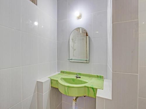 bagno con lavandino verde e specchio di Capital O 92894 Griya Lathifah Homestay Syariah a Kalasan