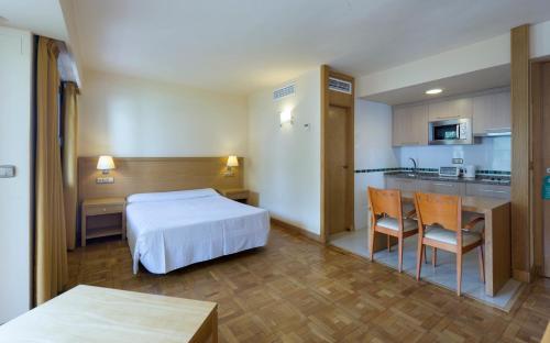 Habitación de hotel con cama y cocina en Apartamentos MS Pepita, en Benalmádena