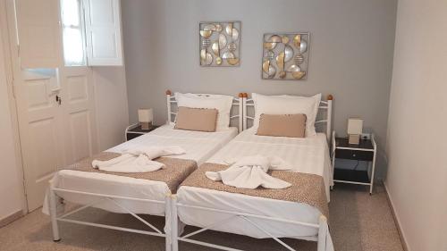 Dos camas en un dormitorio con toallas. en Embati Folegandros rooms en Chora Folegandros