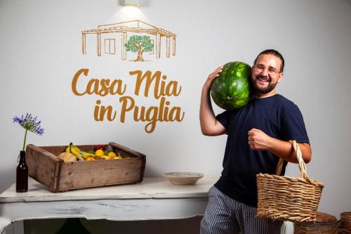 mężczyzna trzymający arbuza i pudełko owoców w obiekcie Casa mia in Puglia w mieście Conversano