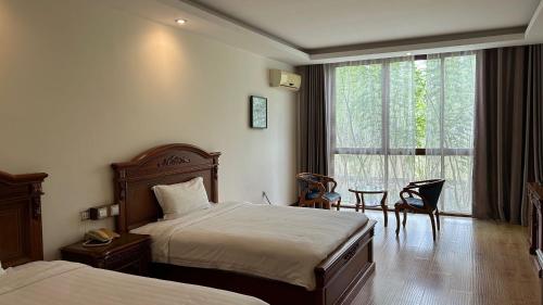 a hotel room with two beds and a window at Victoria Beach Hotel in Toamasina