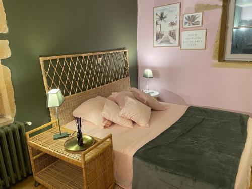 Schlafzimmer mit einem Bett mit Kissen und einem Tisch in der Unterkunft Chambre calme Ouest Lyonnais in Lentilly