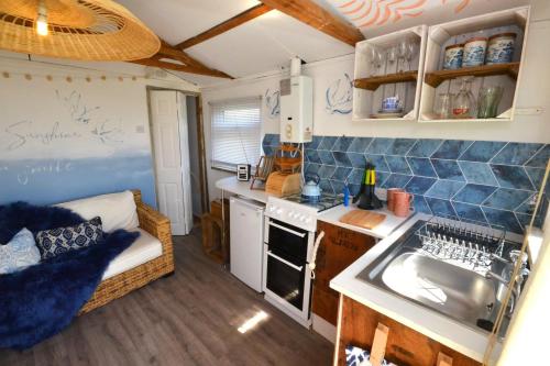 a small kitchen with a sink and a stove at Pips Chalet rest and relax in the Isle of Sheppey in Sheerness