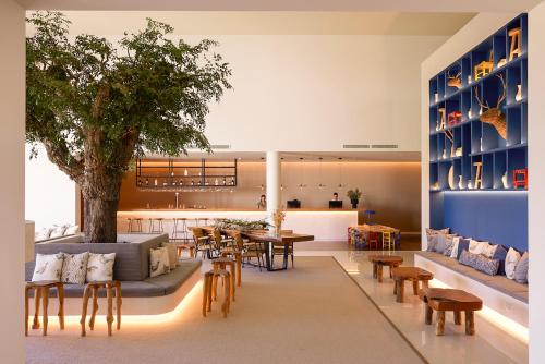 a lobby with a tree and tables and chairs at Octant Evora in Évora