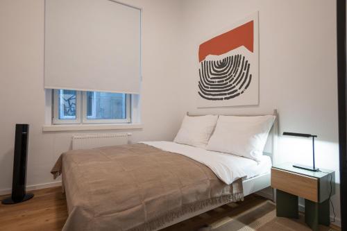 een slaapkamer met een bed en een schilderij aan de muur bij Contemporary 1-Bed Apartment with Balcony in the Heart of Vienna in Wenen