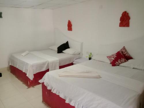 duas camas num quarto com branco e vermelho em Near The Canal Homstay em Sigiriya