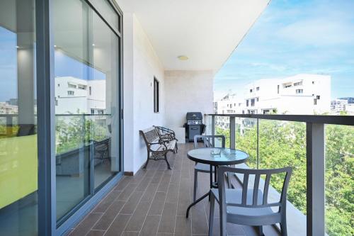 a balcony with a table and chairs on a building at Colorful 3BR with MAMAD by HolyGuest in Tel Aviv