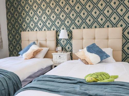 two beds with a stuffed turtle on them in a bedroom at 26 North Promenade in Cleveleys