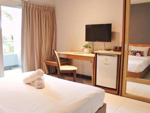 een hotelkamer met een bureau en een bed bij The Finn Hotel / เดอะฟินน์โฮเทล in Ban Liap