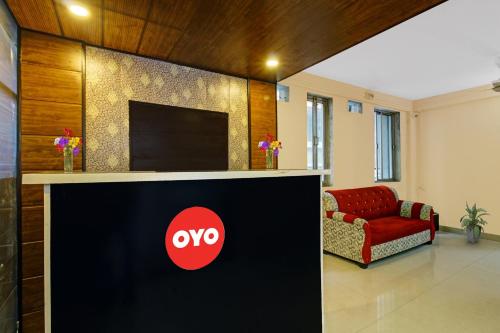 a lobby with a tv and a red couch at Flagship Gopika Stay Inn in Nagpur