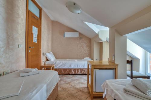 a hotel room with two beds and a table at Hotel Rendez Vous in Kotor