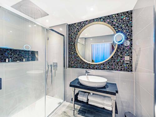 ロンドンにあるメルキュール ロンドン ハイドパーク ホテルのバスルーム(洗面台、鏡付)