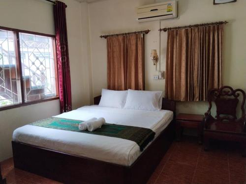 een slaapkamer met een bed met een knuffeldier erop bij Thipphaphone Guesthouse in Pakbeng