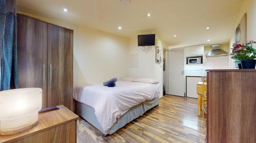 a small bedroom with a bed and a kitchen at 247London Studio Flats in London