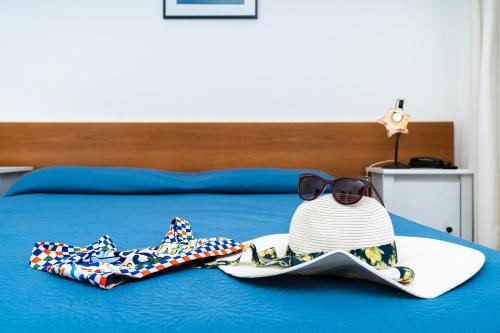 a pair of sandals and a hat and sunglasses on a bed at Hotel Fontana in Amalfi