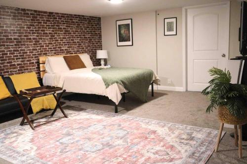 um quarto com uma cama e uma parede de tijolos em Modern Industrial 1BR W/ Gym, Work Desk and More! em Dent