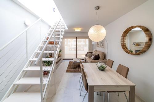 a dining room with a table and a staircase at Mar de Pulpí Las Azucenas by Mar Holidays in San Juan de los Terreros